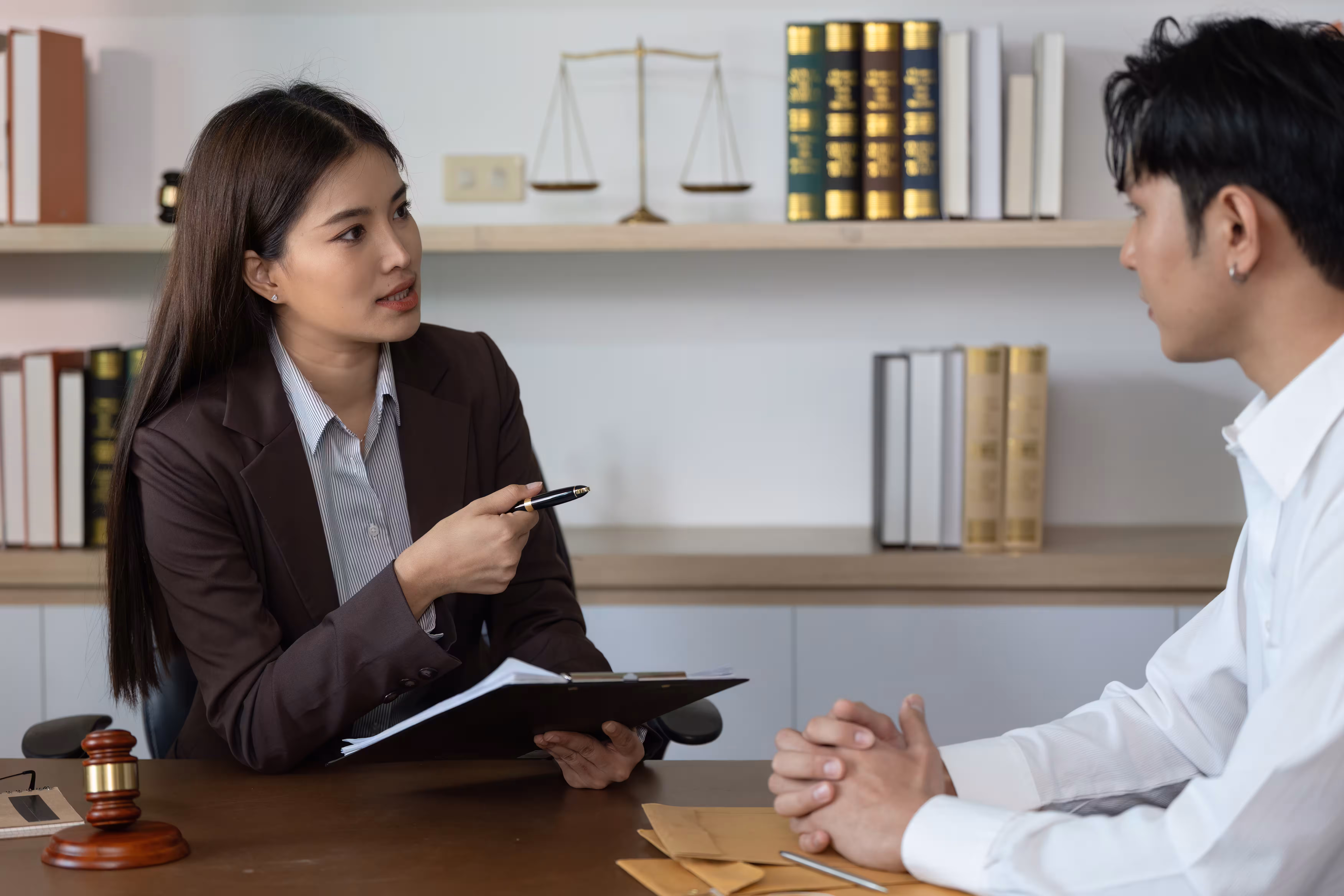 Lawyer explaining documents to a client at a desk