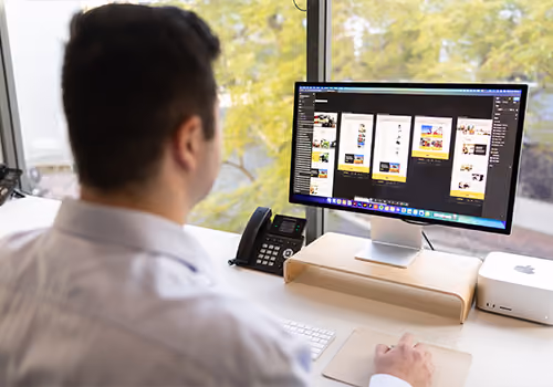 Website design work in progress on screen at the Four Stripes studio.