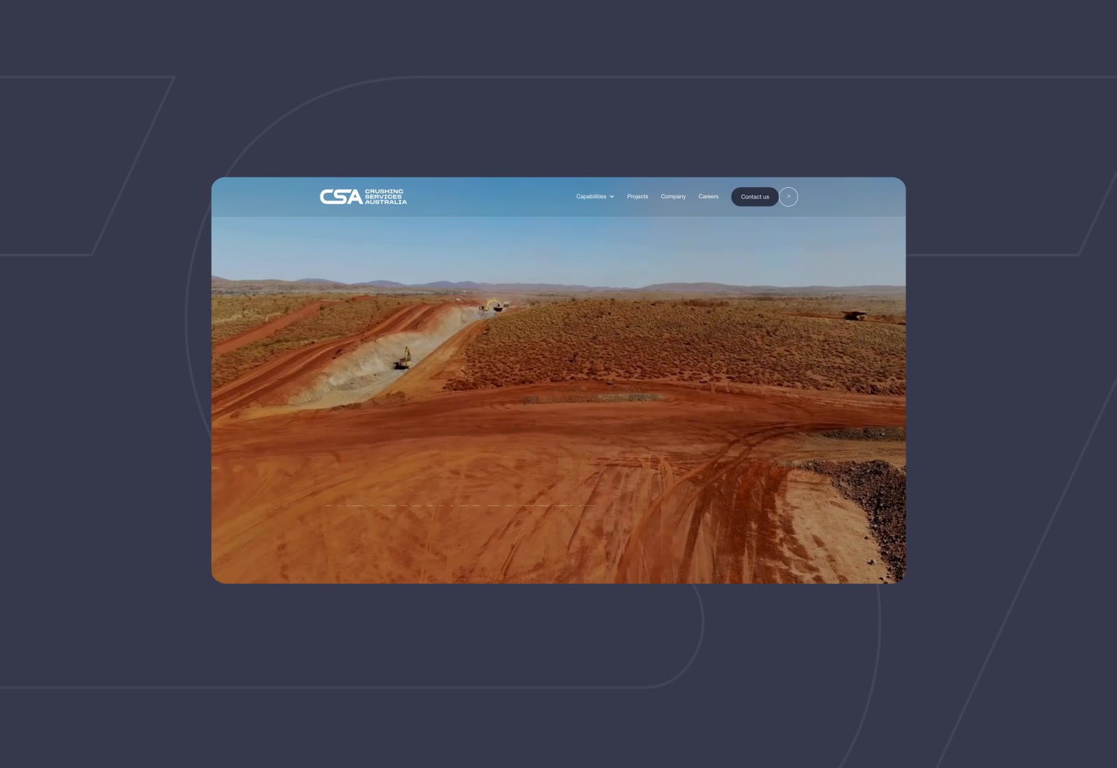 Excavators working on red dirt road construction in arid landscape with hills under clear blue sky.