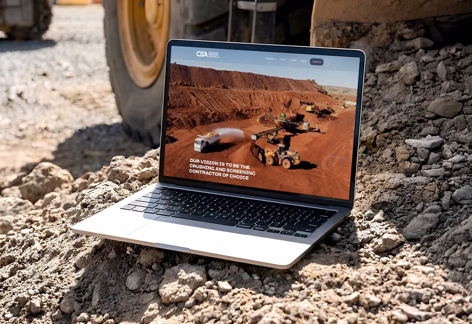 Crushing Services Australia website displayed on a laptop at a quarry.