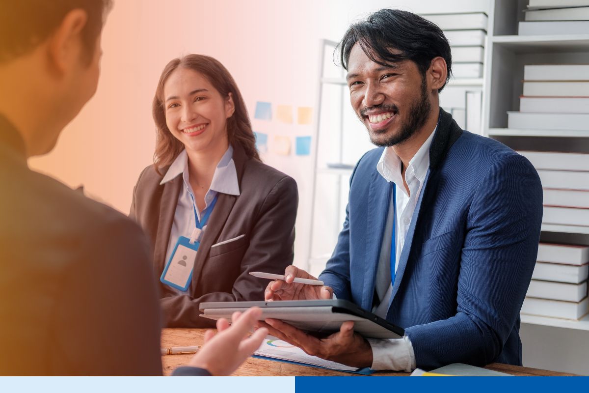 Two smiling corporate professionals with ID badges conducting an interview or consultation using a tablet, illustrating Connext Global Solutions expert guidance on switching EOR providers.
