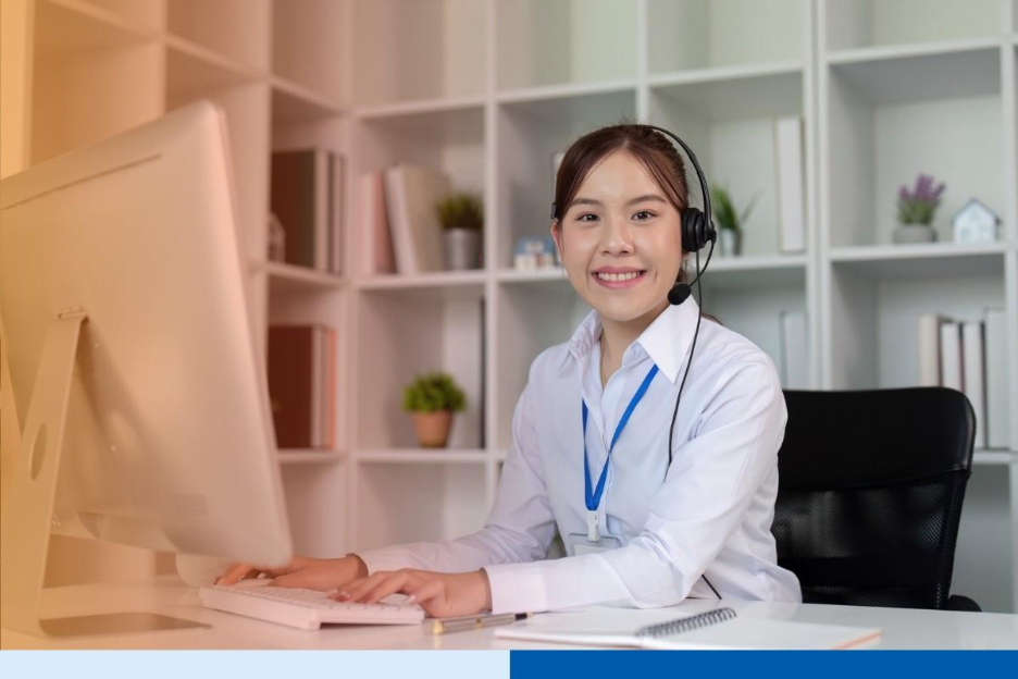 asian woman smiling with desktop n professional corporate attire smiling with office background