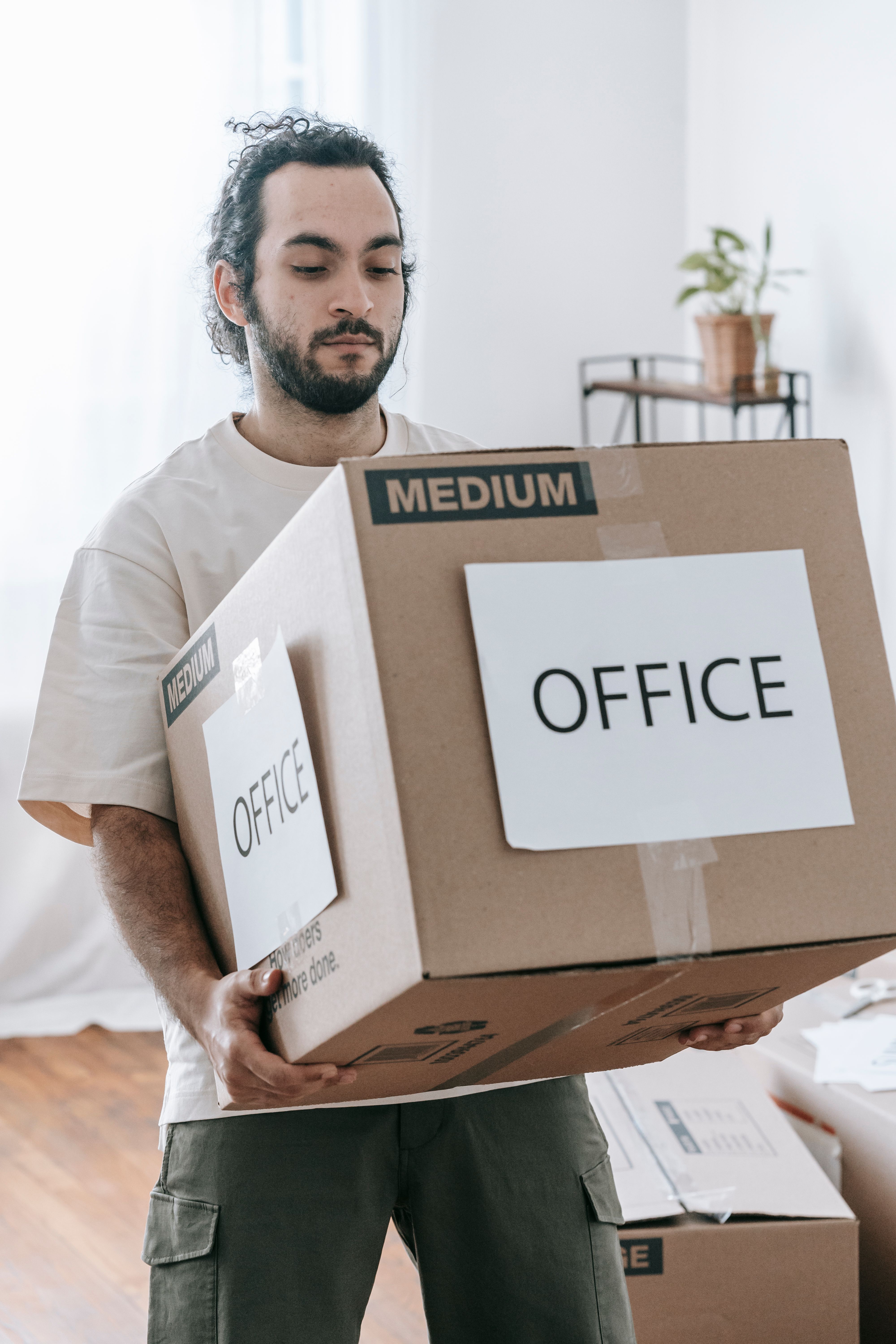Person carrying labeled moving boxes