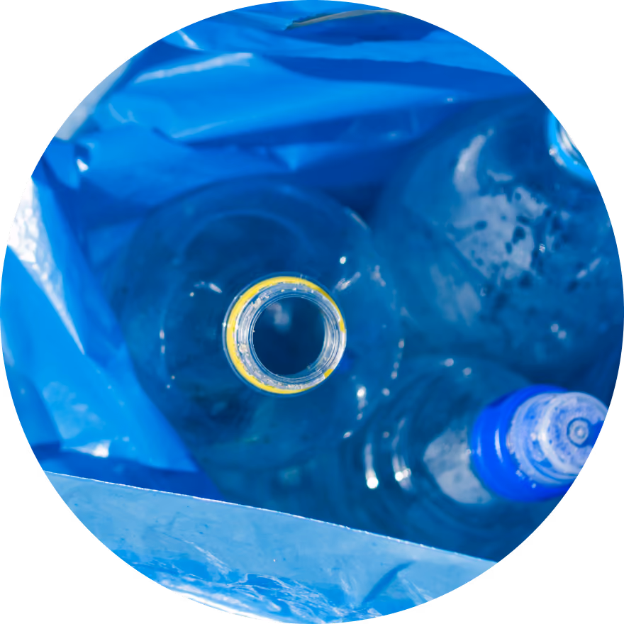 Des bouteilles d'eau en plastique vides à l'intérieur d'un sac de recyclage bleu.