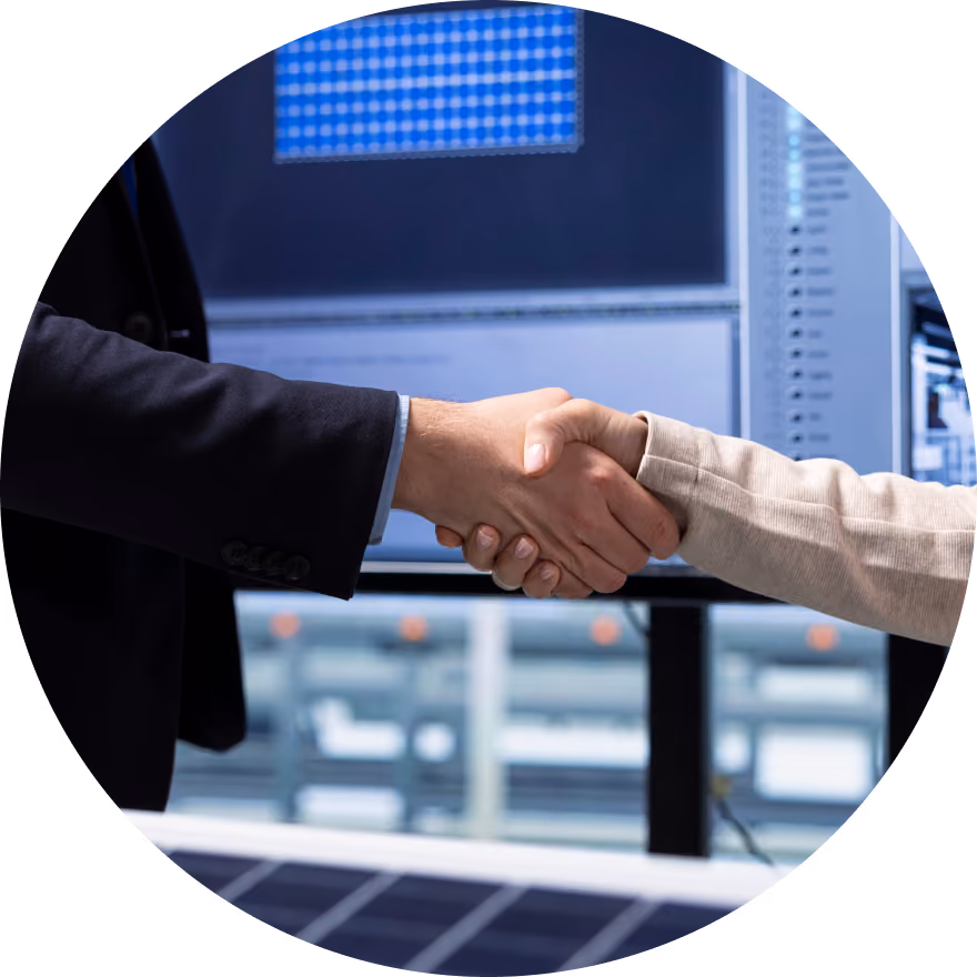 Un gros plan de deux professionnels se serrant la main, avec des écrans de contrôle numériques en arrière-plan.