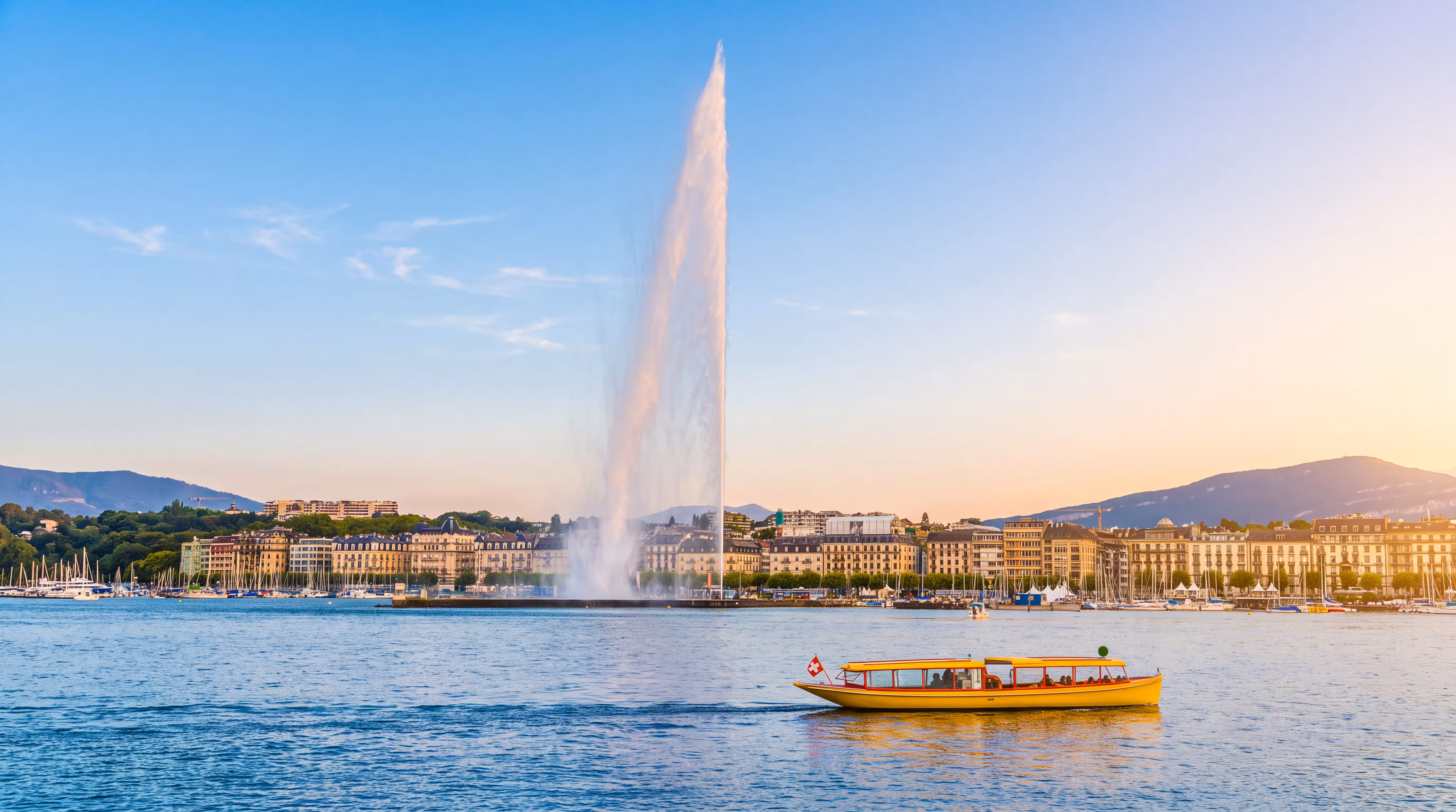 Le Jet d'Eau s'élevant au-dessus du lac Léman à Genève, avec un bateau-taxi jaune au premier plan et le panorama de la ville en arrière-plan.