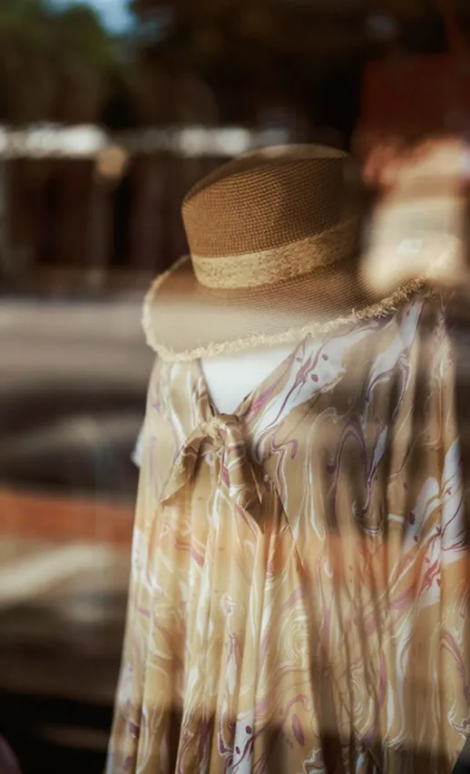 Boutique mannequin wearing a sun hat and patterned dress