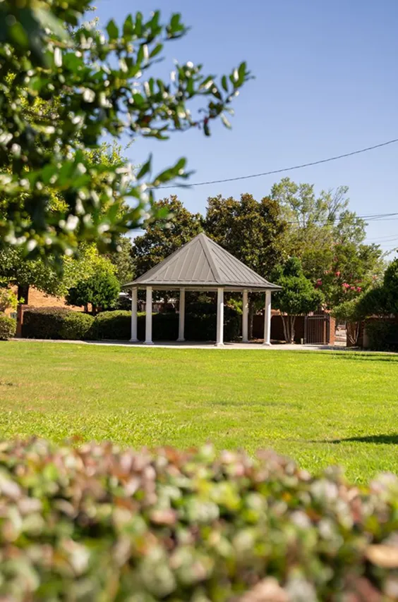 White gazebo on a green lawn in Cheraw