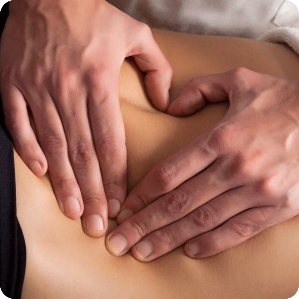 Two hands pressing on a lower back performing a massage.