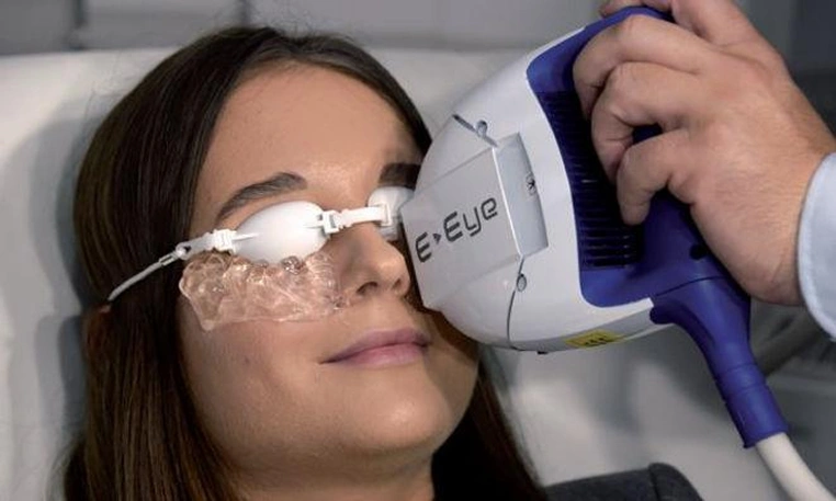 Patient receiving a light-based dry eye treatment with protective eye shields