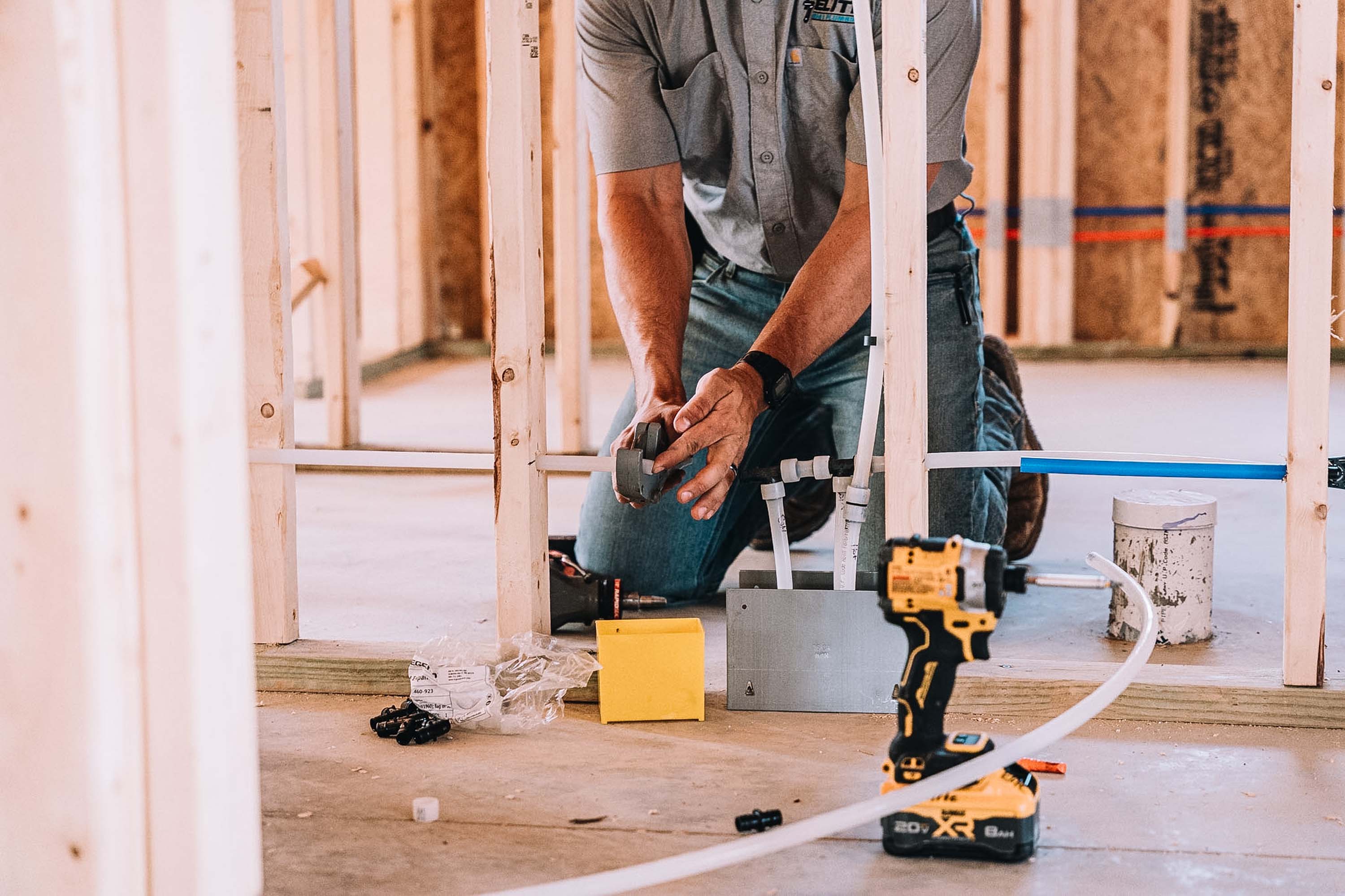 Plumber working on gas piping in new construction framing.