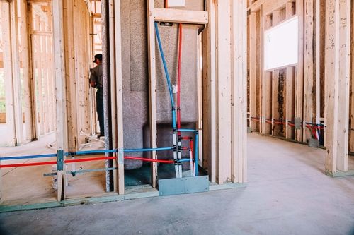 Plumbing installation in new construction framing, showing gas and water lines.