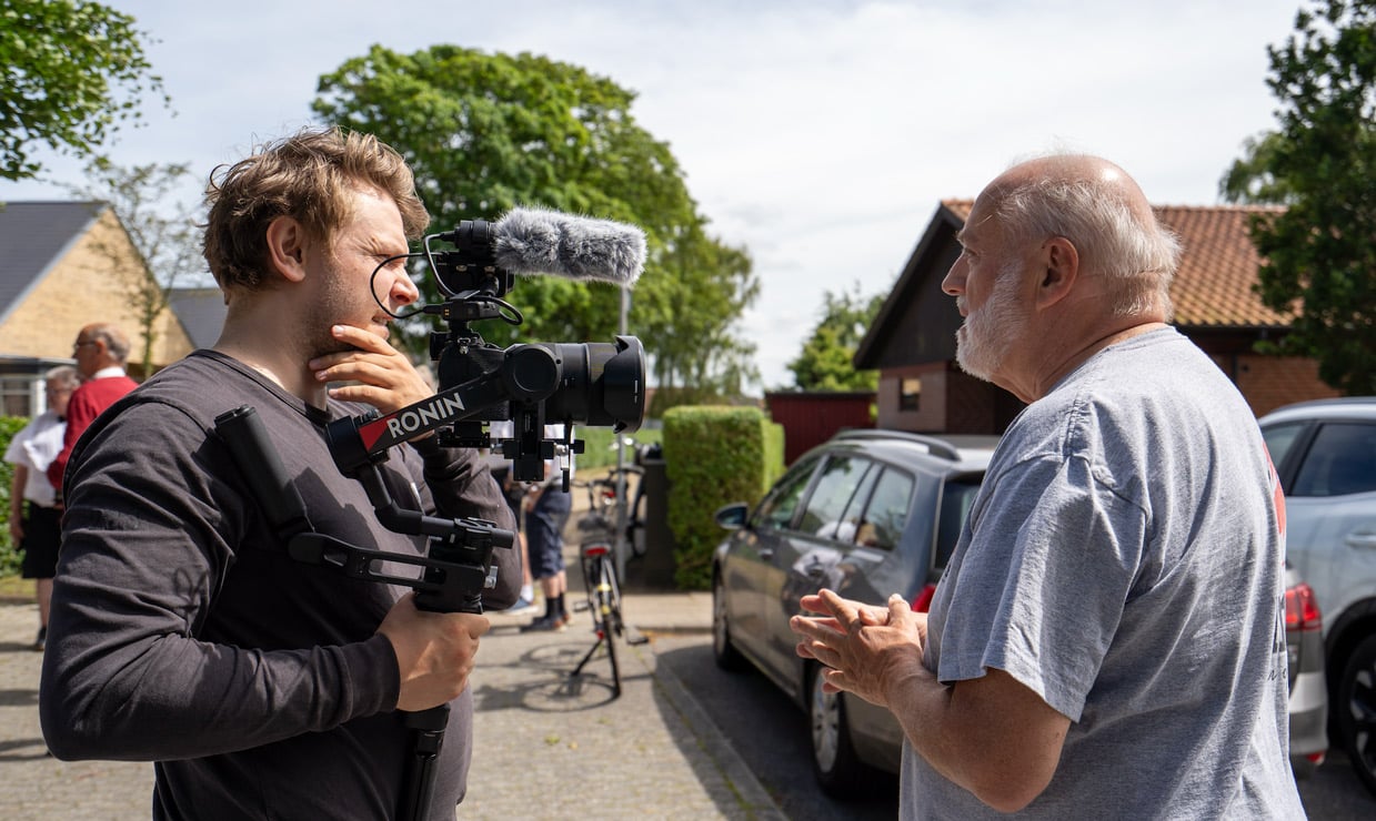Videograf interviewer en mand ved en institution