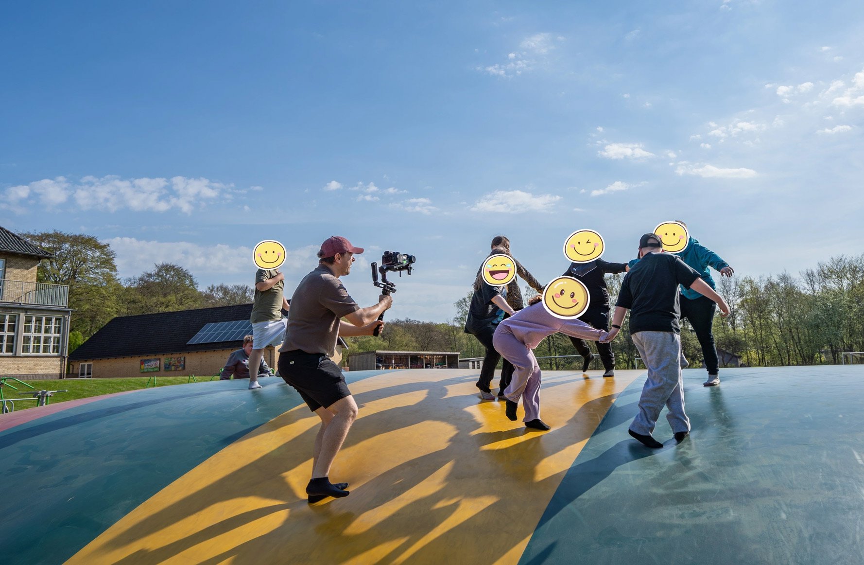Videograf filmer en gruppe på en farverig aktivitetsplads