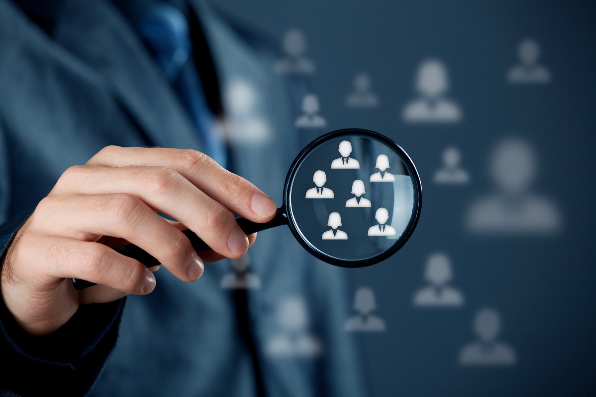 A magnifier glass focusing on a group of people. Understanding TAM - MyStudio insights.