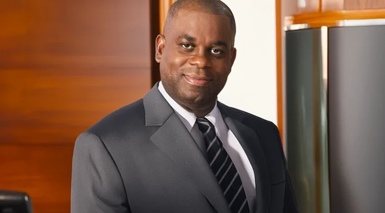 The owner of the cottage who is a dark skin man with a suit and tie on 