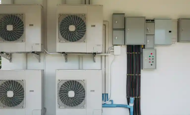 HVAC units and electrical boxes mounted to the wall on the outside of a building