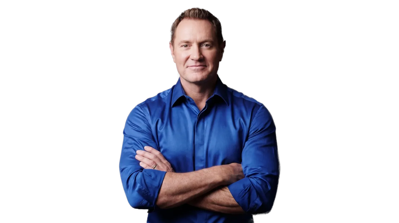 Darren Hardy in front of the wall of SUCCESS magazine covers he published
