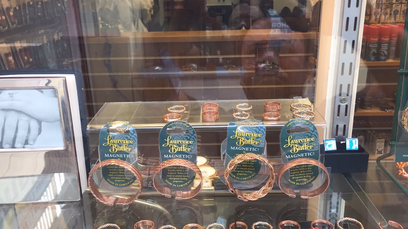 Display of Laurence Butler magnetic copper bracelets and rings in a glass showcase.