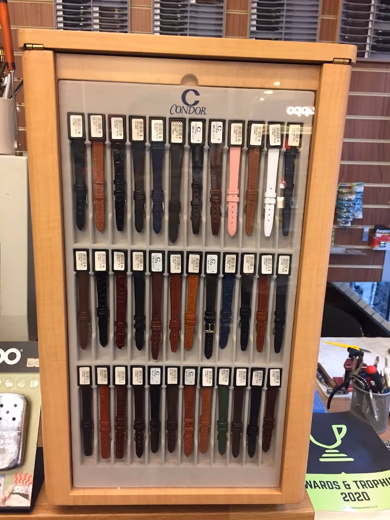Wooden display case holding multiple rows of watch straps in various colors and styles from Condor.