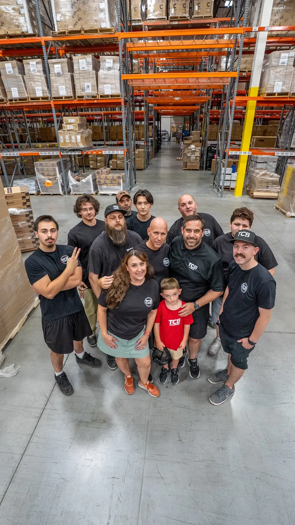 TCB Global team gathered in the warehouse