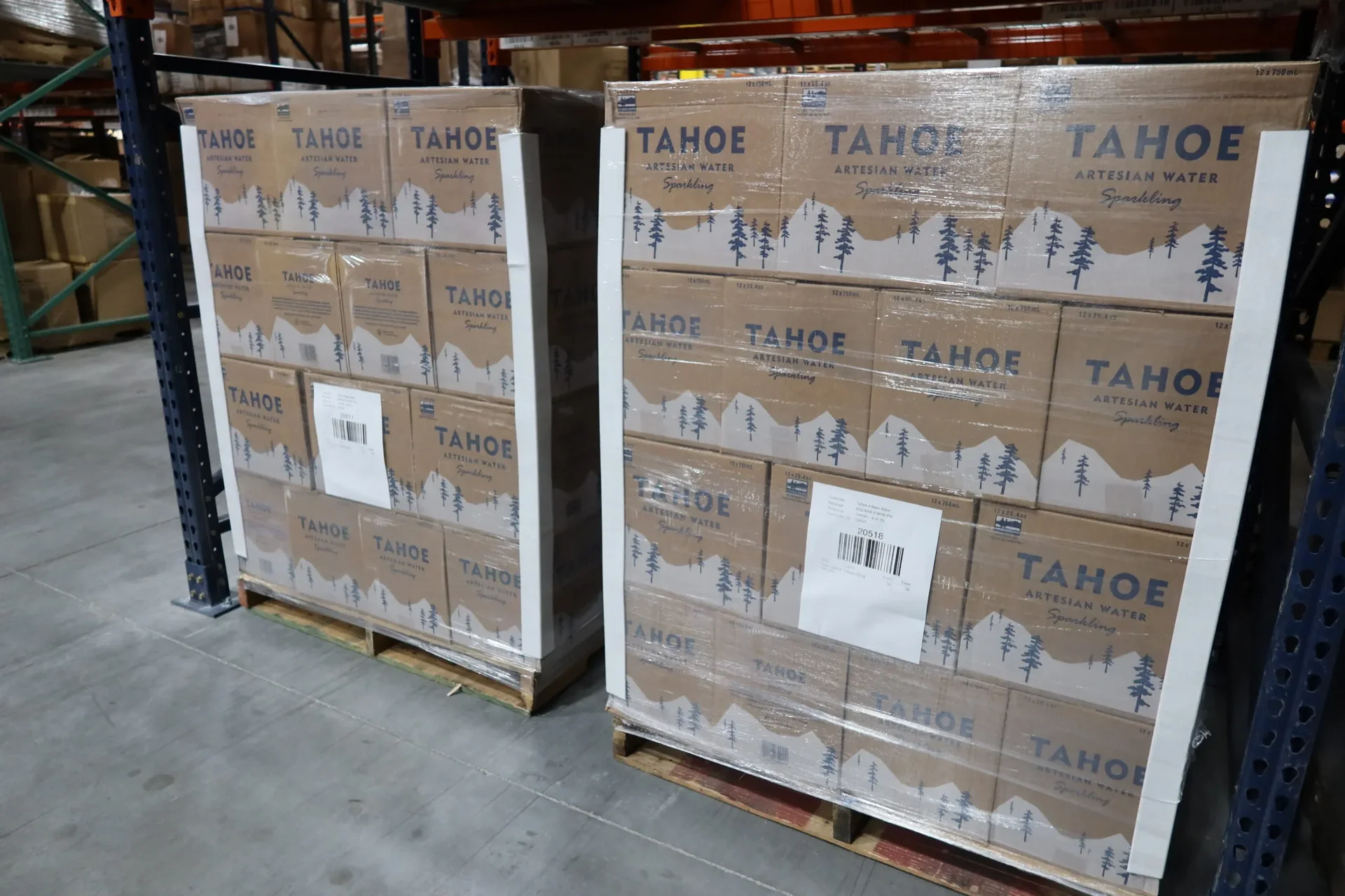 Tahoe canned water cases staged on pallets in a TCB warehouse