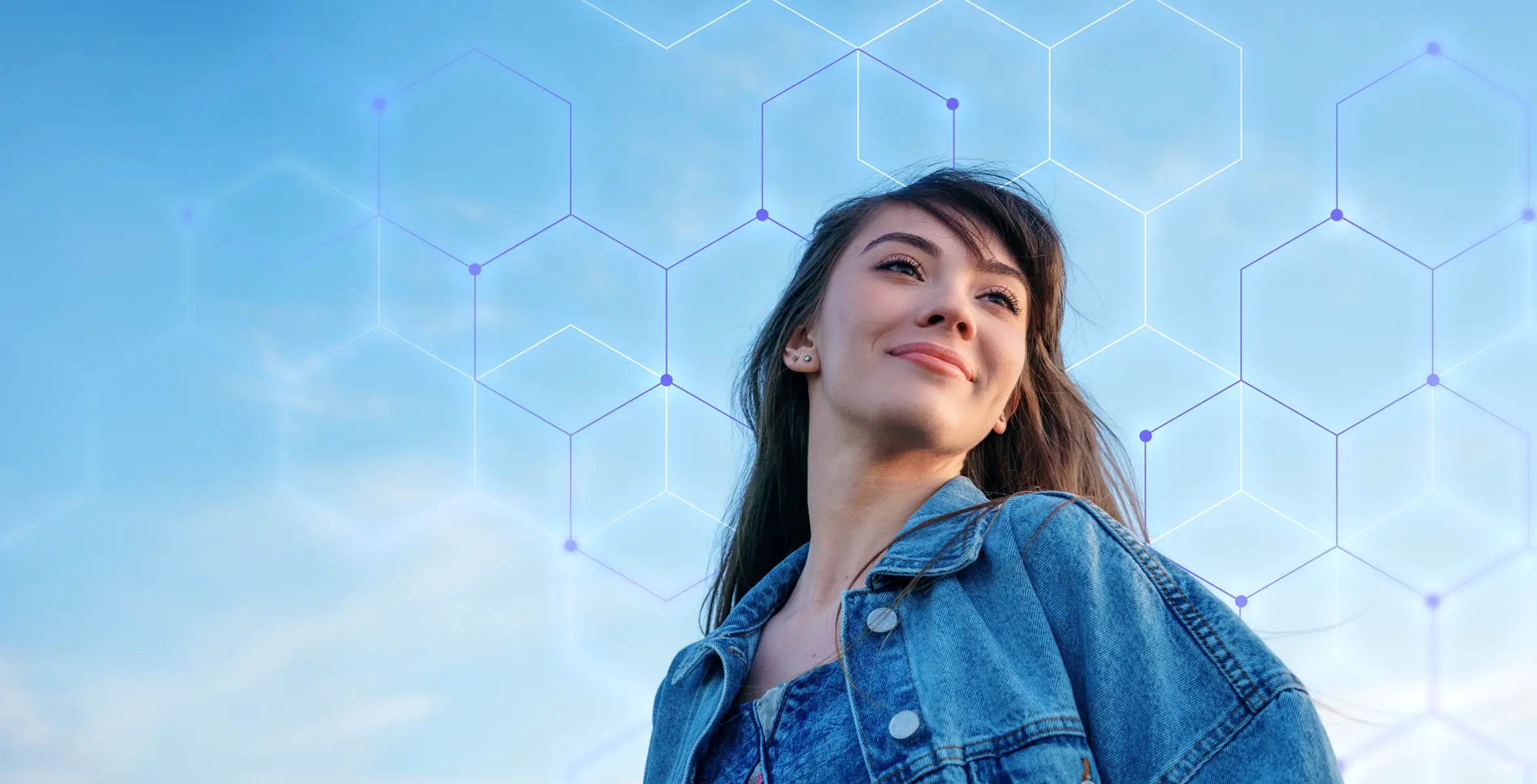 Smiling woman in denim jacket looking upward with hexagonal network pattern over blue sky.