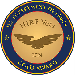 Gold circular medal with dark blue border displaying 'U.S. Department of Labor' at top and 'Gold Award' at the bottom, featuring a stylized eagle and the text 'HIRE Vets 2024' at the center.