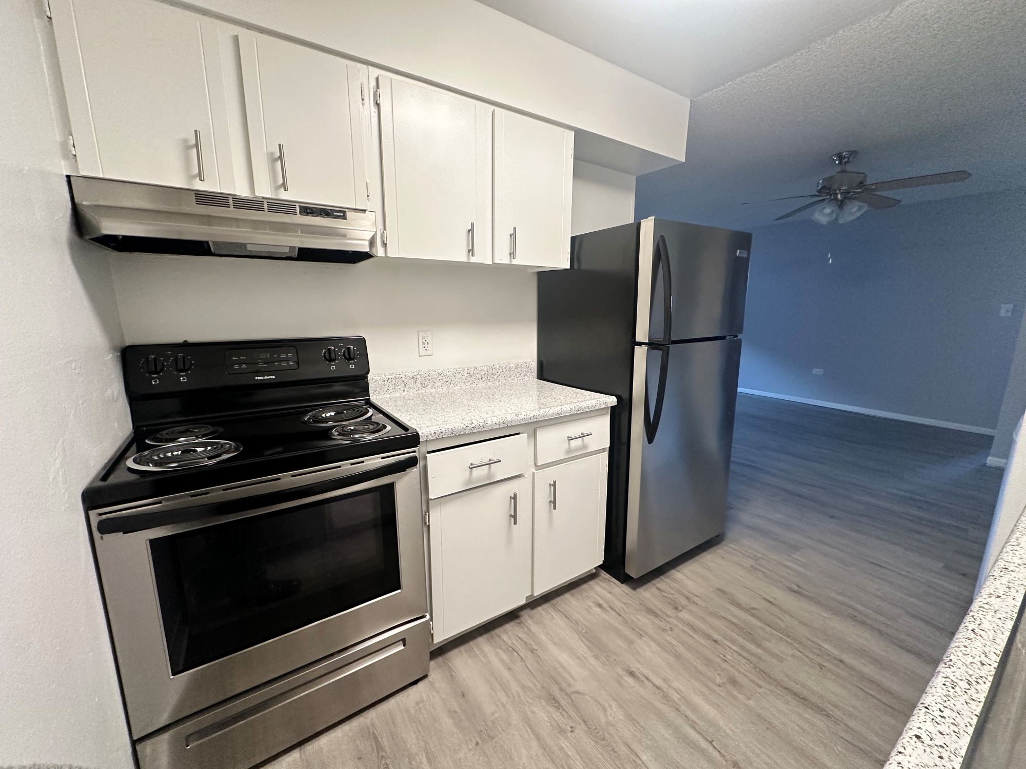 Kitchen with refrigerator and oven, and view of front entry and closet doors