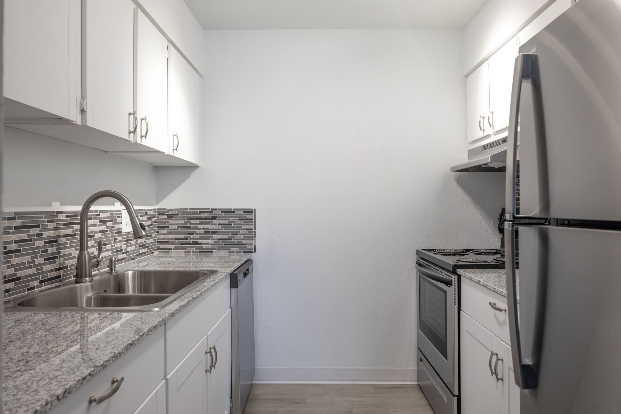 Kitchen with refrigerator and oven, and view of living area