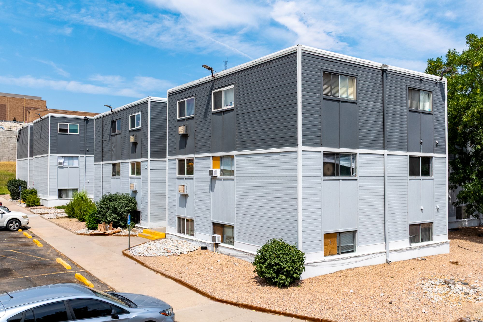 Community exterior with paved walkway, gravel beds, and landscaping