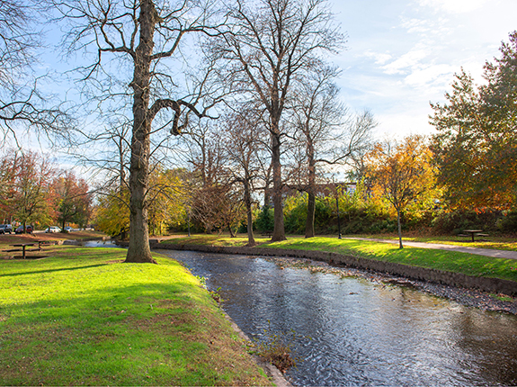 Stream running through Brookside Park with view of walking path