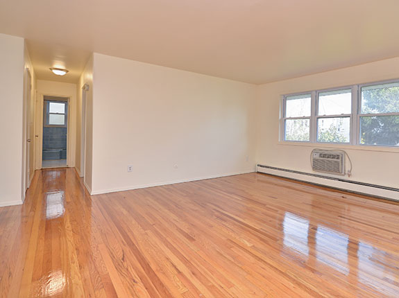 Empty living room featuring shiny hardwood floors