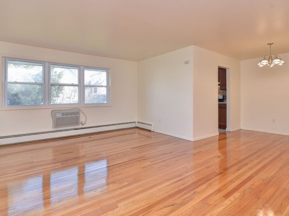 Empty living room featuring shiny hardwood floors