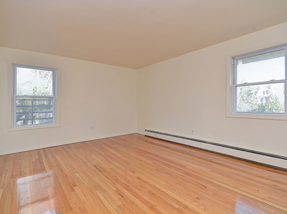 Empty living room featuring shiny hardwood floors