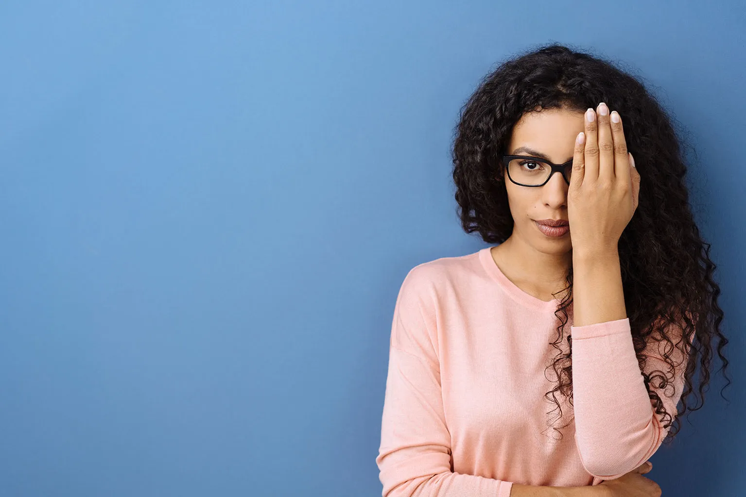 Woman covering one eye during a vision check