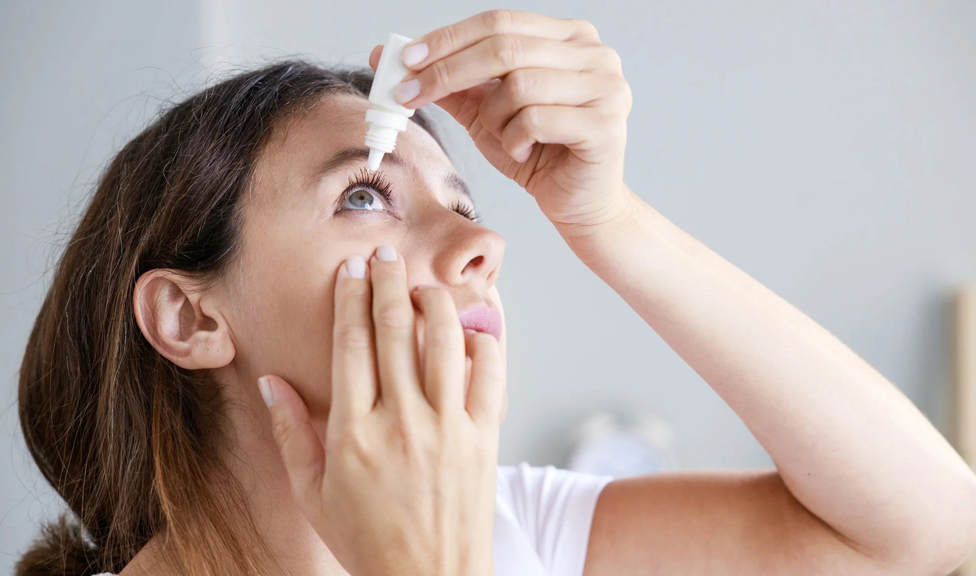 Applying lubricating eye drops