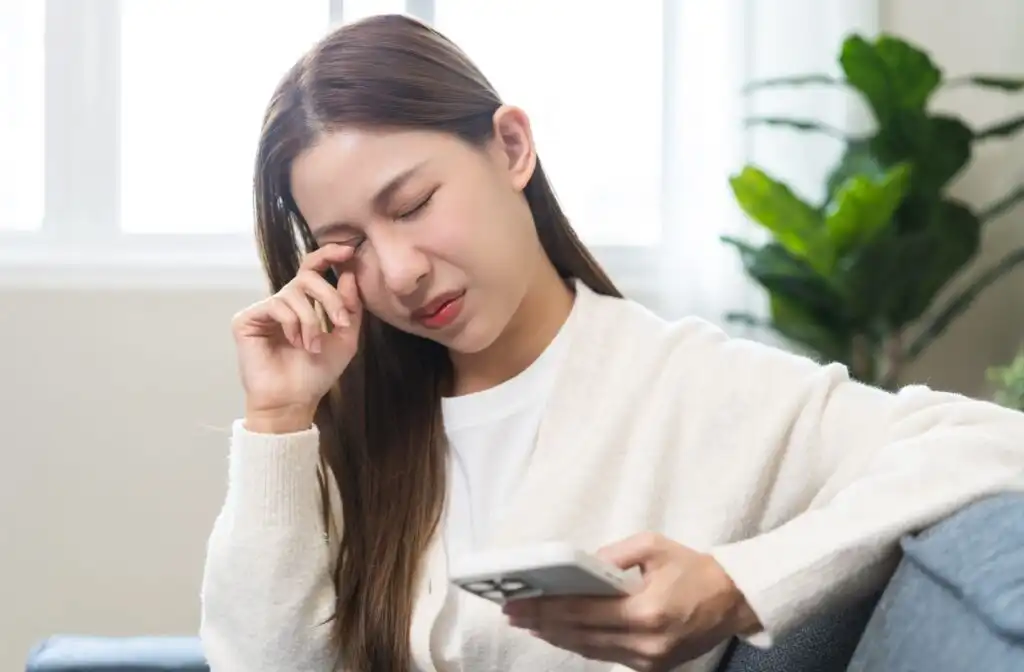 Patient using a phone while experiencing eye discomfort