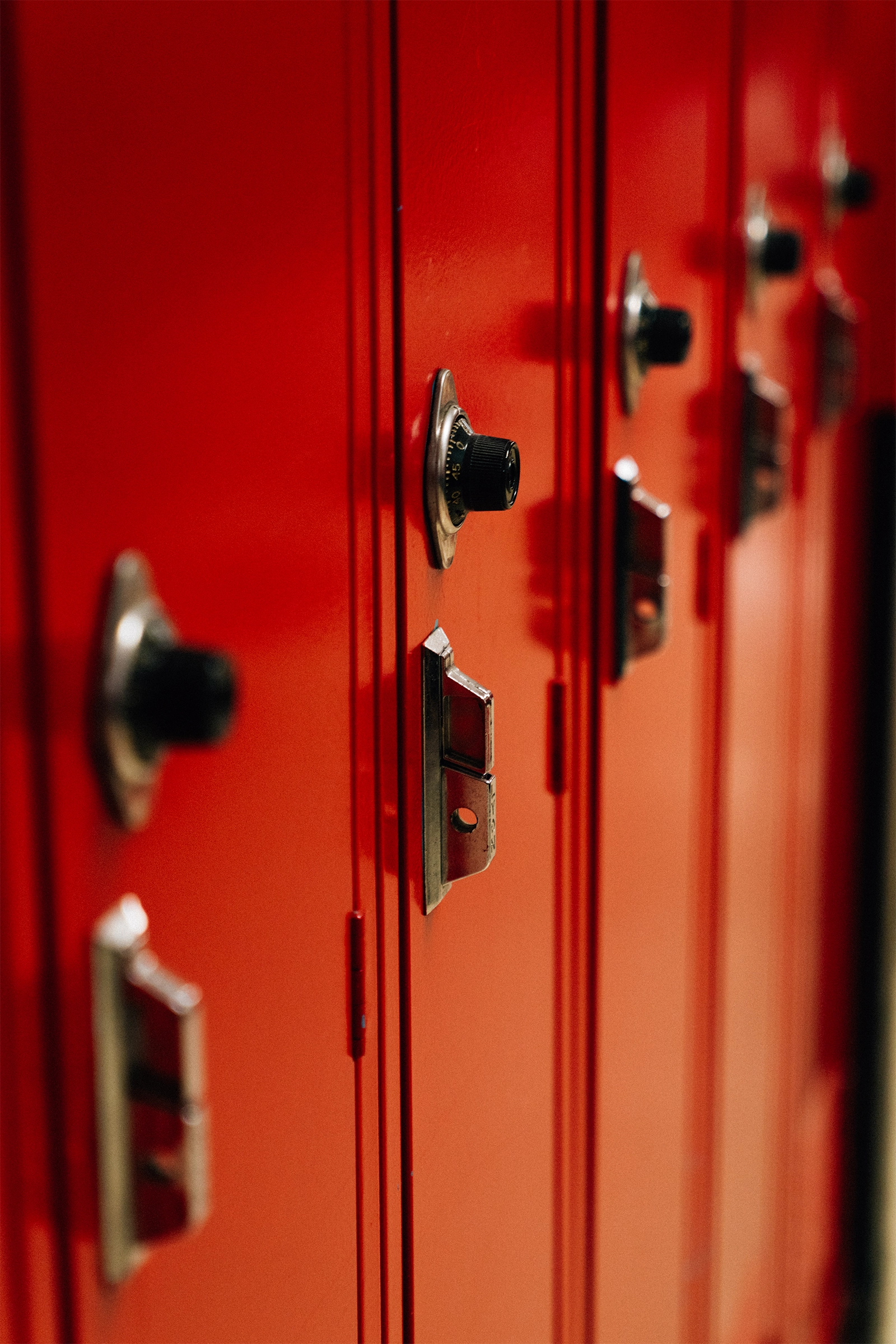 Close-up view of red school lockers with combination locks.
