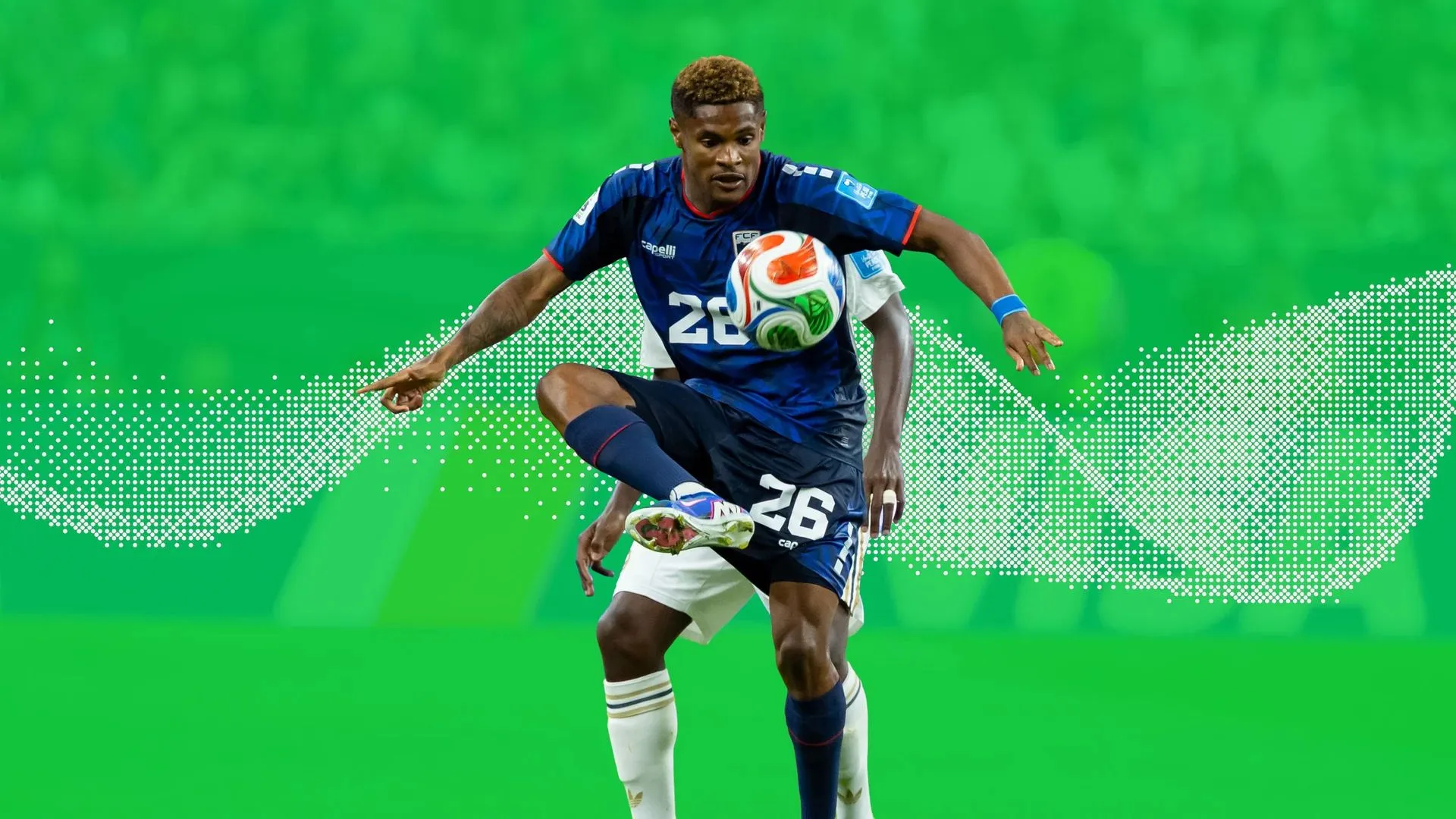 A soccer player controlling the ball against a green ground