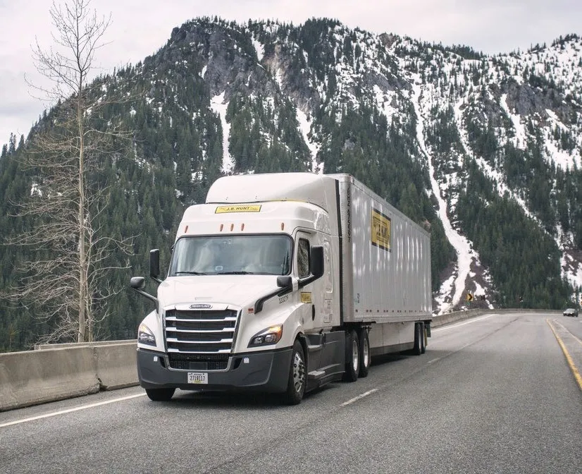A J.B. Hunt truck on a mountain highway in winter