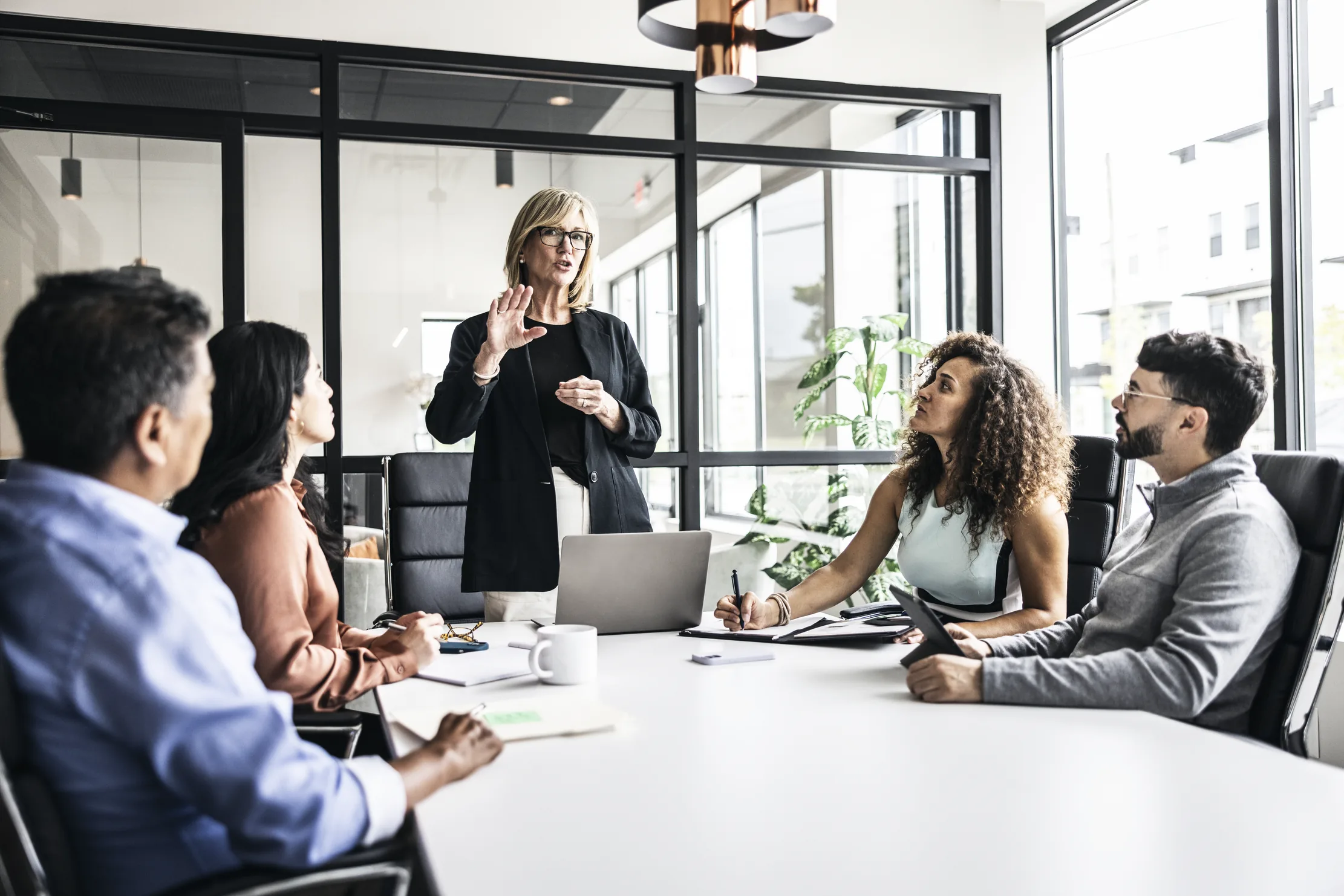 An executive leading a discussion around a conference table