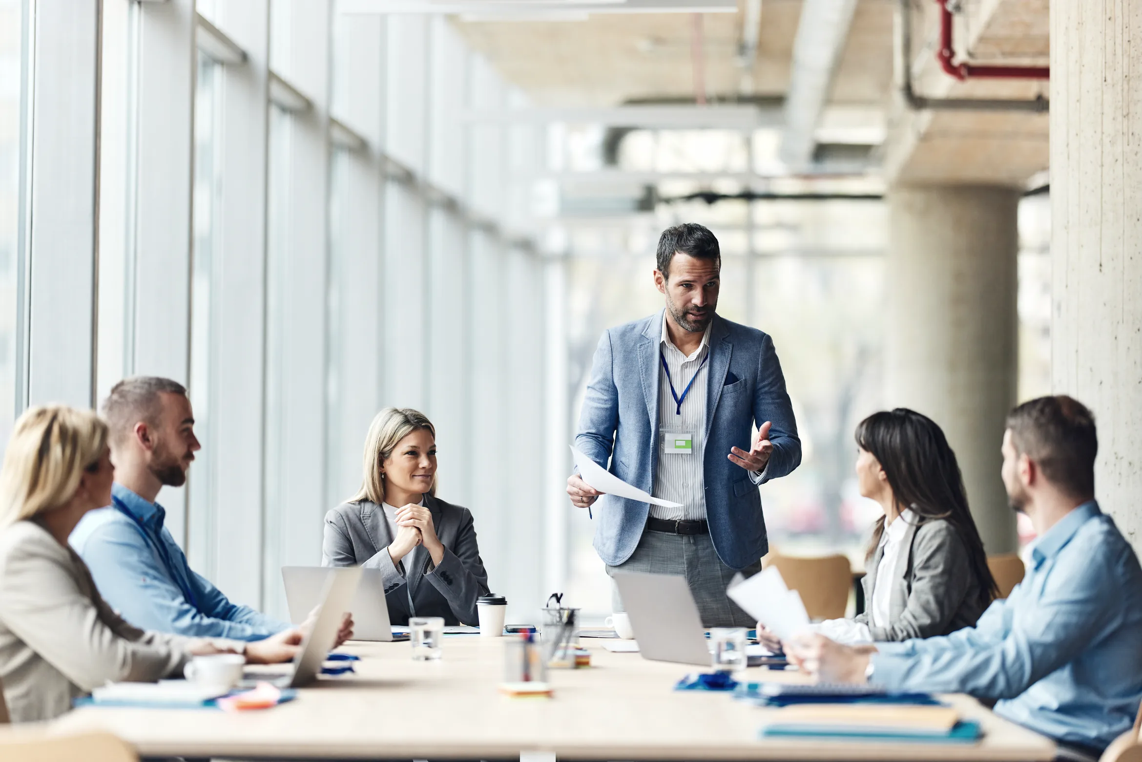 A leader standing at the head of the table, talking his team through a plan