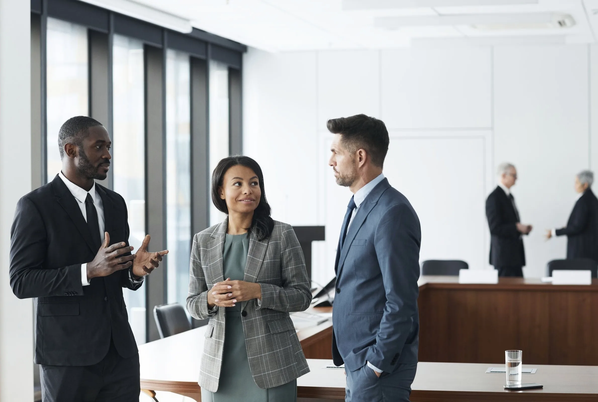 Three colleagues talking through a problem in a meeting room