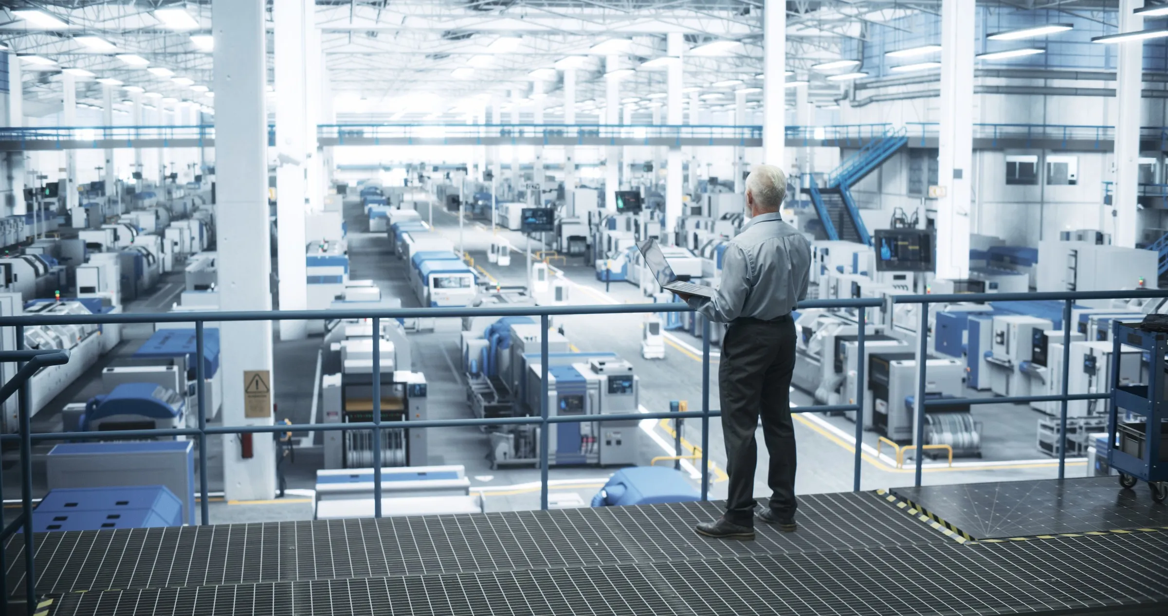 A manager on a walkway above a machining floor