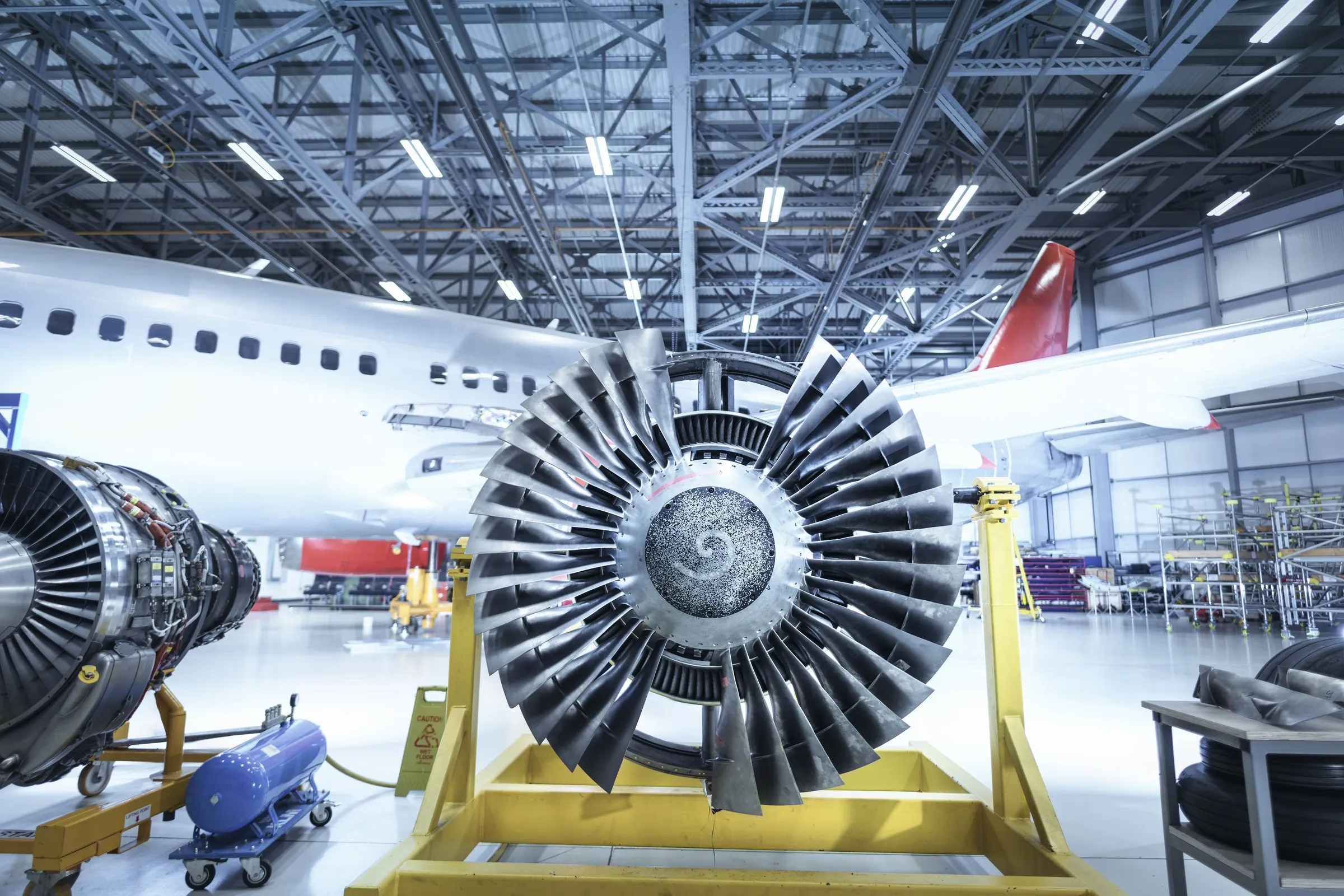 A jet engine on its stand in a maintenance hangar