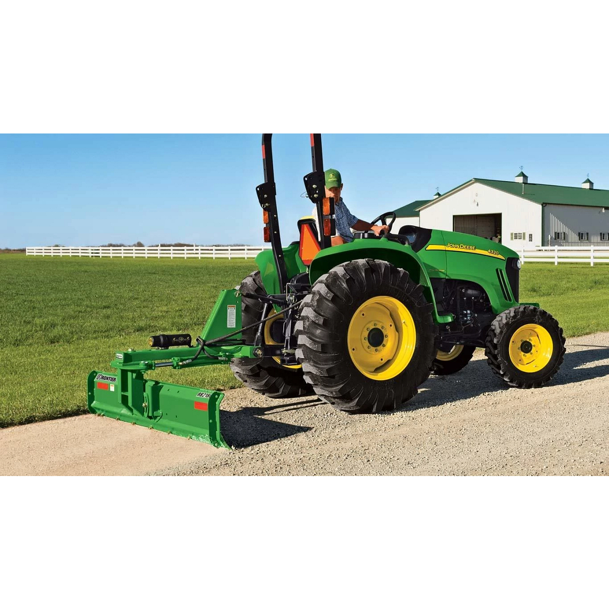 Farmer driving a tractor with a Frontier RB21H rear blade down a dirt road
