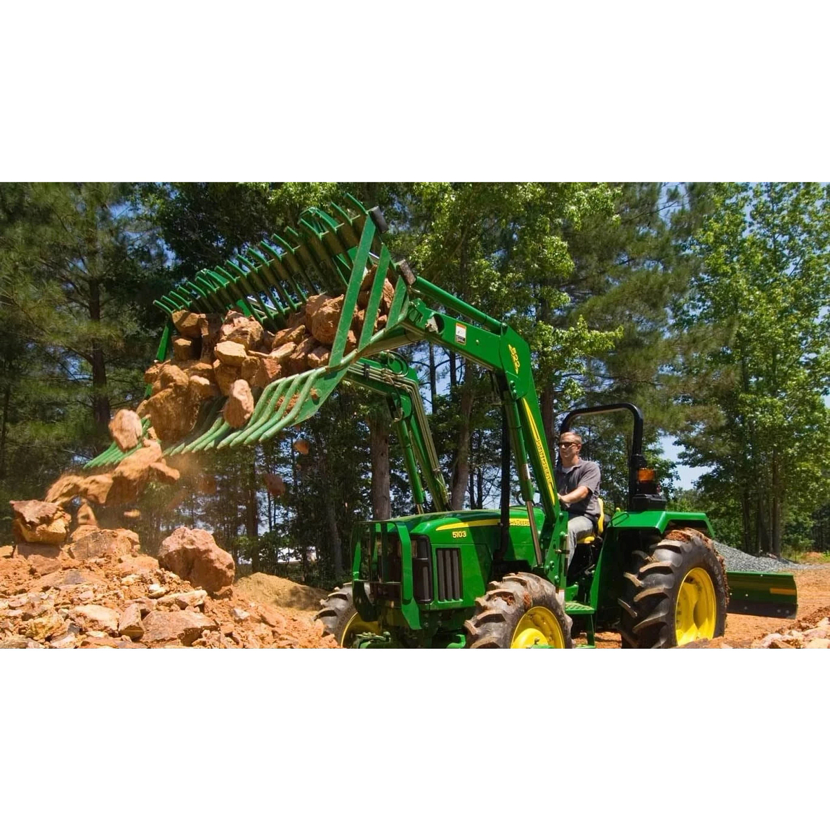 Frontier AR10 Rock Bucket attachment on a tractor dumping boulders