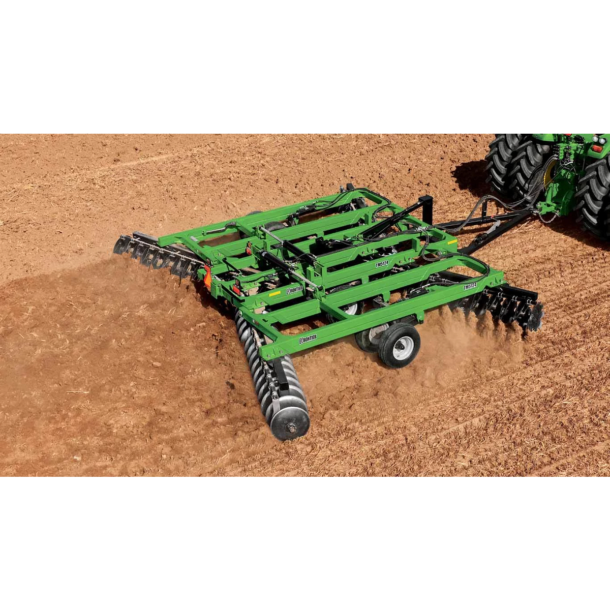 TM51 Series Tandem Disk Harrow pulled through a large dirt field by a tractor
