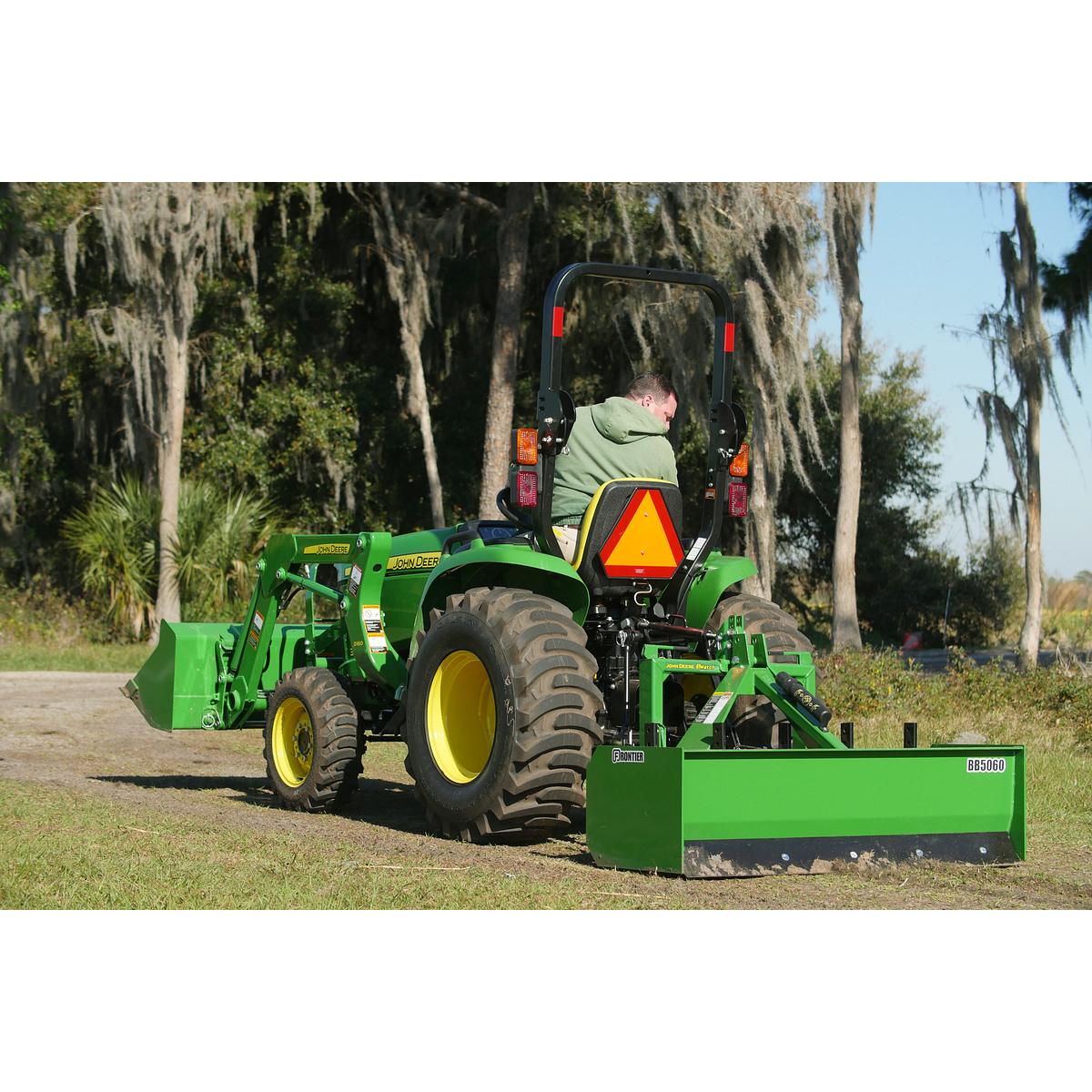 Rear left view of an operator using a Frontier BB50 Box Blade on a dirt track